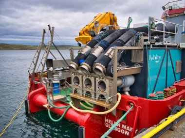 Smir Hidrolik Ekipmanı, İngiltere 'nin Shetland kentindeki Lerwick Limanı' nda demirli Helen Mary iş gemisinde. Bulutlu bir günde çekilmiş. Arka planda sarı bir vinç görünüyor..