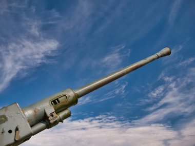 1942 model 40 mm 'lik Bofors topunun namlusu açık beyaz bulutlu mavi bir gökyüzünü işaret ediyor. İkinci Dünya Savaşı 'nda yaygın olarak kullanılan İsveç yapımı bir uçaksavar silahıydı..