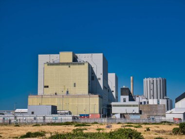 Dungeness A (Magnox - solda) ve Dungeness B (AGR - sağda), Kent, İngiltere 'deki Dungeness burnu üzerinde faaliyet göstermeyen nükleer enerji santralleri. Yazın güneşli bir günde çekilmiş..