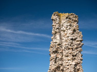 Reculver, Herne Bay, Kent, İngiltere 'deki ortaçağ kilisesinde yıpranmış ve harap olmuş bir tuğla koleksiyonu. Güneşli bir günde, mavi bir gökyüzünde çekildi..