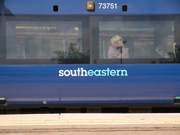 Die Seite Eines Blauen Südostbahnwagens Hinter Einem Der Beiden Fenster Stockbild