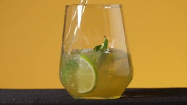 Ferahlatıcı bir soda toniğinin yakın çekimi. Limonlu ve buzlu bir bardağa soda dök. Soğuk mojito limonata. Sırt çantası. Serinletici bir yaz içkisi bir bardağa dolduruldu.