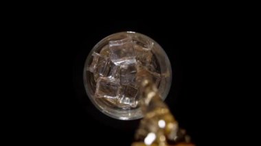 Buzlu soda dolduruyorum. Buzlu ve camında kabarcıklar olan dönen camların üst görüntüsü. Gazoz yakın çekim. Siyah arka plan. Yavaş çekim video görüntüleri. Makro Vuruş.