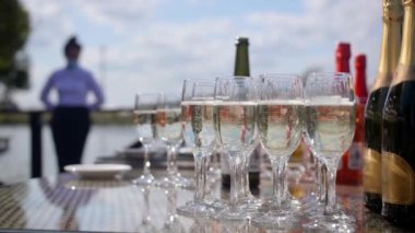 Şenlik masasında duran kadehlerle şampanya köpürüyor. Açık hava düğün büfesi.