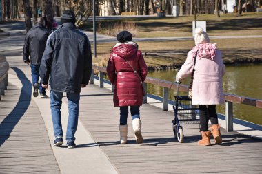 İnsanlar bahar zamanı parkta yürüyorlar.