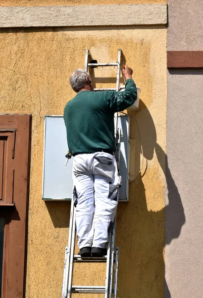 Człowiek Pracuje Drabinie Obok Ściany — Zdjęcie stockowe