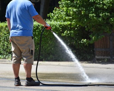 Adam caddeleri suluyor.