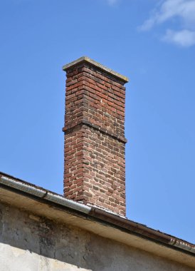 Duman yığını ve bir evin çatısı