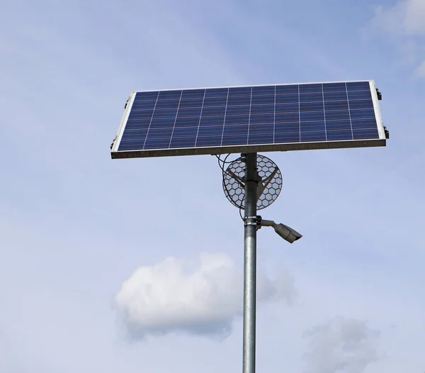 Solar panel and security camera on a metal pole