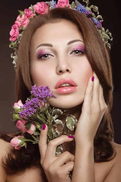 Schönes Mädchen mit perfekter Haut und leuchtendem Blumenkranz auf dem Kopf. — Stockfoto