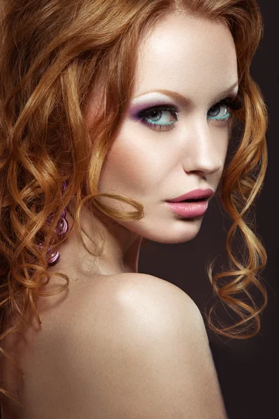 Piękna rudowłosa dziewczyna jasny makijaż i loki. — Zdjęcie stockowe