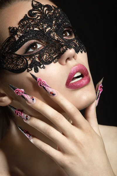 Hermosa chica en una máscara con uñas largas . — Foto de Stock