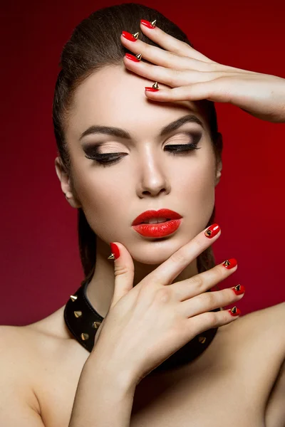 Vacker kvinna med kvällen make-up och röda naglar med törnen. — Stockfoto