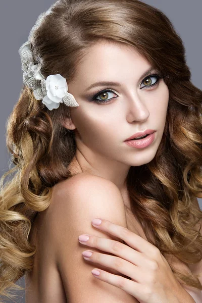 Beautiful girl in wedding image with flowers in her hair — Stock Photo, Image