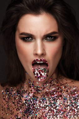 Kırmızı dudaklı, klasik makyajlı ve ışıltılı kıvırcık saçlı güzel bir kız. Güzel surat. Fotoğraf stüdyoda çekildi..