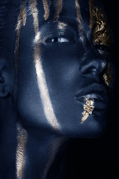 Retrato de moda de una chica de piel azul con maquillaje dorado. Cara de belleza. Imágenes de stock libres de derechos