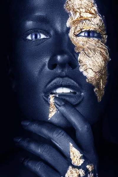 Retrato de moda de una chica de piel azul con maquillaje dorado. Cara de belleza. Imagen de stock