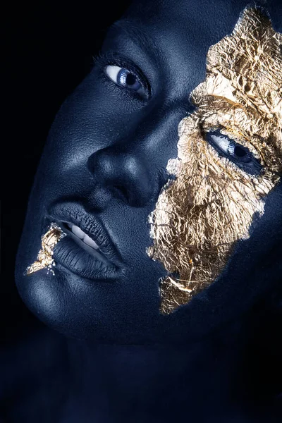 Retrato de moda de una chica de piel azul con maquillaje dorado. Cara de belleza. Fotos de stock