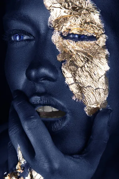 Retrato de moda de una chica de piel azul con maquillaje dorado. Cara de belleza. Fotos de stock libres de derechos