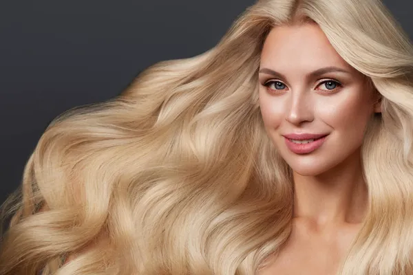Красивая блондинка с идеально вьющимися волосами и классическим макияжем. Красота лица и волос. — стоковое фото