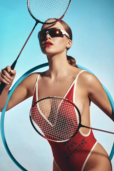Schöne attraktive Frau im trendigen Badeanzug mit Sportausrüstung und Accessoires. Stockfoto