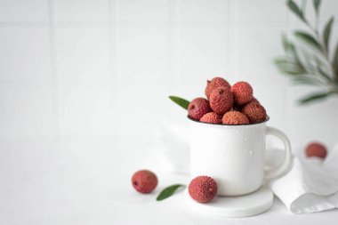 large ripe lychees fruit in a white mug, close-up