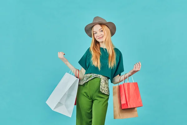 快乐的年轻女人拿着购物袋呆着 漂亮的女孩走购物中心背着许多蓝色背景的好货包 — 图库照片