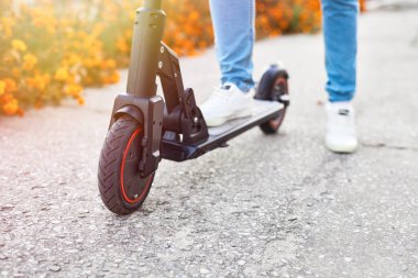 Yenilenebilir enerji ve çevre dostu ulaşım konsepti. Şehirde elektrikli scooter kullanan bir adam. Gelişmiş ulaşım.