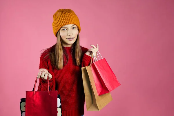 快乐的年轻女人拿着购物袋呆着 漂亮的女孩步行购物中心背着很多包好东西 背景是粉色的 — 图库照片