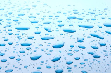 Su damlaları mavi arkaplanda. Yüzeye bir damla su. Makro fotoğraf. Sıçrama deseni. Yakın plan..