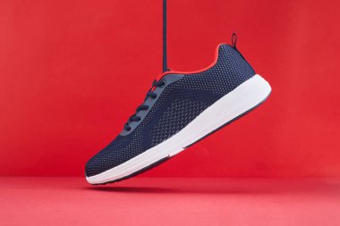 Renkli spor ayakkabılar ya da kırmızı arka planda ayakkabılar. Spor ve spor için mavi spor ayakkabıları çalıştırmak.