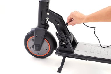 Beyaz arka planda siyah motorlu motorun pili şarj işlemi.