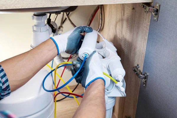 手袋の配管手は台所で水フィルターカートリッジを交換します 浄化浸透圧システムを修正 ろ過装置の設置又は修理の技術者 — ストック写真