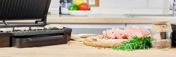 バーベキューキッチンのインテリアで準備 キッチンテーブルの上で電気グリルバーベキューや肉 ロイヤリティフリーのストック画像