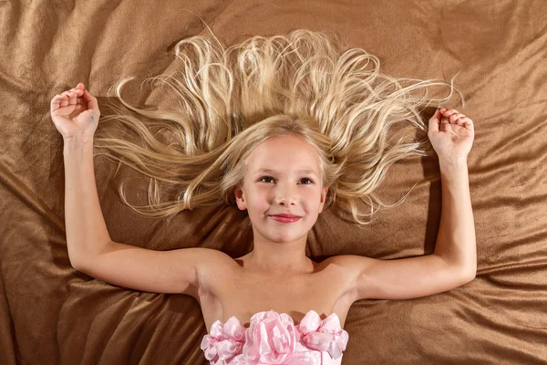 Beautiful little girl dreaming on bed — Stock Photo, Image