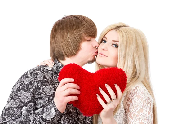 Feliz pareja besando y sosteniendo el corazón de San Valentín rojo — Foto de Stock