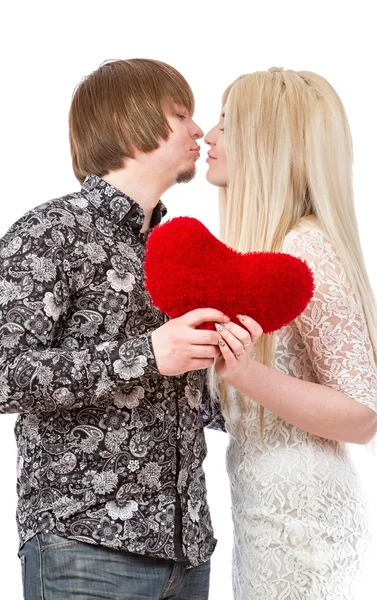 Feliz pareja besando y sosteniendo el corazón de San Valentín rojo — Foto de Stock