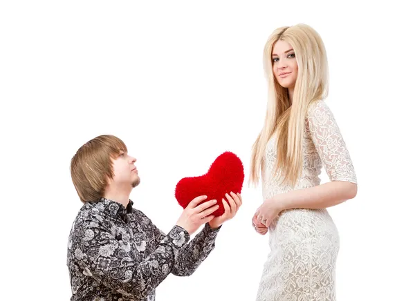Romantiska mannen på knä håller ett rött hjärta och en upphetsad blo — Stockfoto