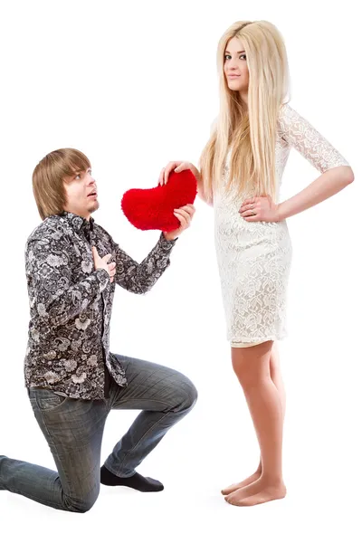 Romantic man on his knees holding a red heart and an excited blo — Stock Photo, Image