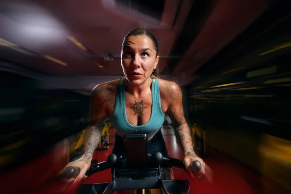 zooming on woman in gym spin class