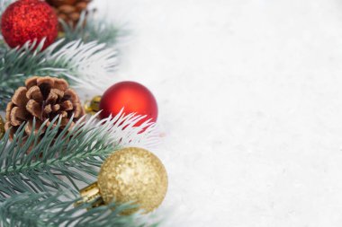 Noel ağacı oyuncağı kırmızı ve altın top kar arka planda ağaç konisi