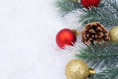 Noel ağacı oyuncağı kırmızı ve altın top kar arka planda ağaç konisi