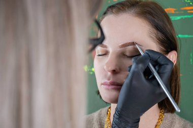 Bir güzellik salonunda fırça düzeltme, boyama ve kaplama prosedürü ile kaş boyama, göz tedavisi