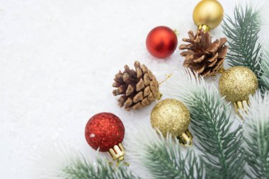 Noel ağacı oyuncağı kırmızı ve altın top kar arka planda ağaç konisi