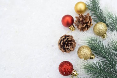 Noel ağacı oyuncağı kırmızı ve altın top kar arka planda ağaç konisi