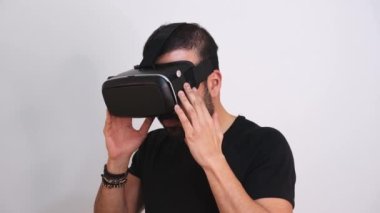 VR gözlüklerini çıkaran genç adam el kol hareketi yapıyor. Sanal gerçeklik, gelecek teknolojisi, eğitim video oyunu