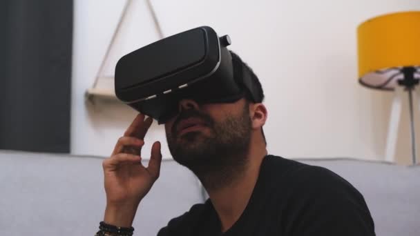 Jovem com óculos VR em casa interagindo com a realidade virtual, sorrindo. Fecha. tecnologia futura, educação jogos de vídeo — Vídeo de Stock