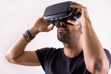 Young man in VR glasses headset holding with hands, close up portrait. Virtual reality, future technology, education video gaming