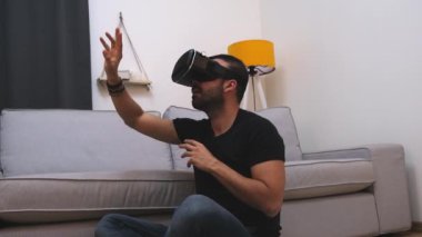 VR gözlüklü genç adam evde sanal gerçeklikle etkileşimde, gülümsüyor. Kapat. gelecek teknolojisi, eğitim video oyunu