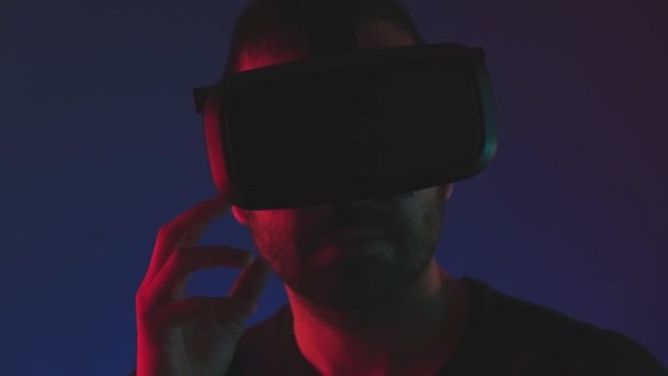 Νεαρός άνδρας με γυαλιά VR αλληλεπιδρούν με την εικονική πραγματικότητα στο χρώμα νέον φως, κλείστε τη μελλοντική τεχνολογία, την εκπαίδευση video gaming — Αρχείο Βίντεο